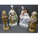 TWO STAFFORDSHIRE FLATBACKS and a pair of biscuit porcelain figurines of a young boy and girl