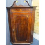 ANTIQUE MAHOGANY CORNER CUPBOARD with broken swan neck pediment over a single opening door with