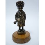 VINTAGE CAR MASCOT- STANDING CHAUFFER wearing cap and goggles, holding a horn, circa 1920s, 9cms H.