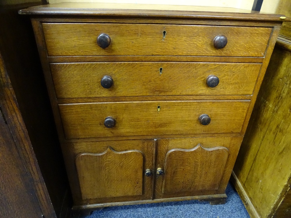 A NEAT ANTIQUE OAK CHEST of 3 long top drawers with 2 base cupboards, 76 cms wide,