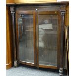 19TH CENTURY ROSEWOOD BOOKCASE having two glazed doors, column supports with carved acanthus