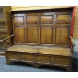 18TH CENTURY JOINED OAK BOX SETTLE, angled top with brackets above eight paneled tall back,