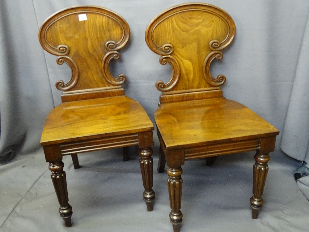 PAIR OF VICTORIAN MAHOGANY HALL CHAIRS having carved shaped detail to the backs, on reeded and