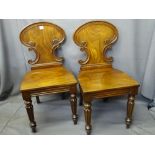 PAIR OF VICTORIAN MAHOGANY HALL CHAIRS having carved shaped detail to the backs, on reeded and