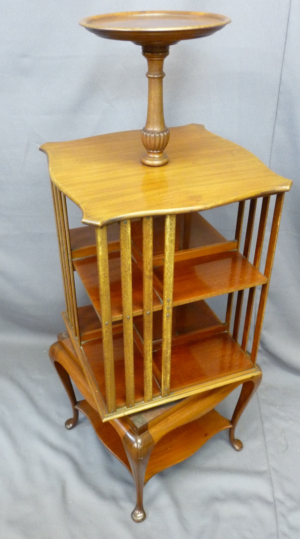 EDWARDIAN MAHOGANY REVOLVING BOOKCASE having dish tray top on slender supports with under tier
