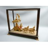 CARVED WOOD INDIAN DISPLAY depicting a horse drawn carriage, cased (glass missing)