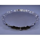 SILVER SALVER, of plain form, uninscribed and with stepped, wavy rim and three scrolled supports,