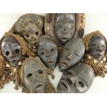 EIGHT VARIOUS DAN MASKS some with fibre and shell assemblages (8)