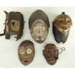 FIVE VARIOUS AFRICAN MASKS including ljo hippo mask, Lega mask, and Punu mask (5)