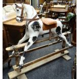 EARLY 20TH CENTURY DAPPLE ROCKING HORSE, leather mane, later saddle on trestle base, 143cms long