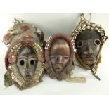 THREE DAN MASKS all with large shell decorated cloth assemblages (3)