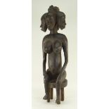 SENUFO SEATED FEMALE FIGURE, carved with five faces, 65cms high