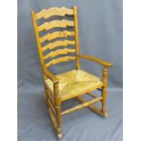 VINTAGE LADDERBACK FARMHOUSE ROCKING ARMCHAIR, rush seated, 98cms H, 56.5cms W, 41cms D the seat