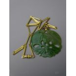 LARGE CARVED JADE PENDANT with 10k yellow gold scrolled hanger and yellow metal bar and rings