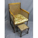 VINTAGE BERGERE ARMCHAIR on bobbin front supports and a similarly styled footstool, 95cms H, 60.5cms