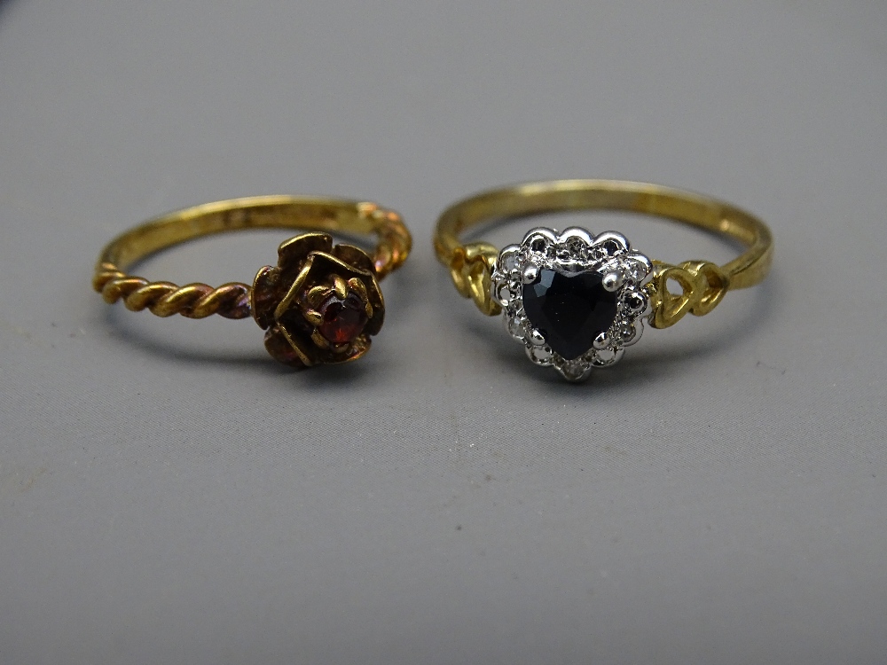 TWO NINE CARAT GOLD RINGS, one of sapphire and diamonds heart shape, the other of ruby flower form