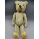 CIRCA 1910/20 BABY TEDDY BEAR with jointed limbs and glass eyes, 29cms long