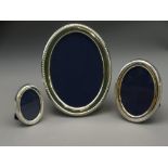 SET OF THREE MATCHING SILVER PHOTO FRAMES of oval form and graduated size (largest 16cms),1988