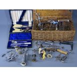 CASED CUTLERY and a collection of vintage and later corkscrews in a Moet & Chandon wicker basket