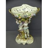 CONTINENTAL FLORAL BEDECKED TWO-HANDLED OVAL BASKET, the column in the form of 'young boy and