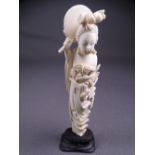 CIRCA 1910 JAPANESE IVORY FIGURINE of a floral bedecked lady holding a mirror behind her head on a
