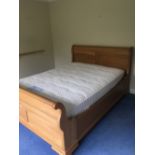 A MODERN OAK EFFECT DOUBLE SLEIGH BED WITH SLATS