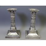 PAIR OF SILVER CANDLESTICKS, square based classical decoration with Corinthian columns and shaped