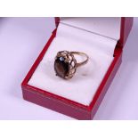 9CT GOLD SMOKEY QUARTZ DRESS RING, the oval facet cut stone set in a raised openwork mount, 3.2grms,