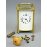 FRENCH BRASS CARRIAGE CLOCK with winding key and others having Roman numerals set to a white