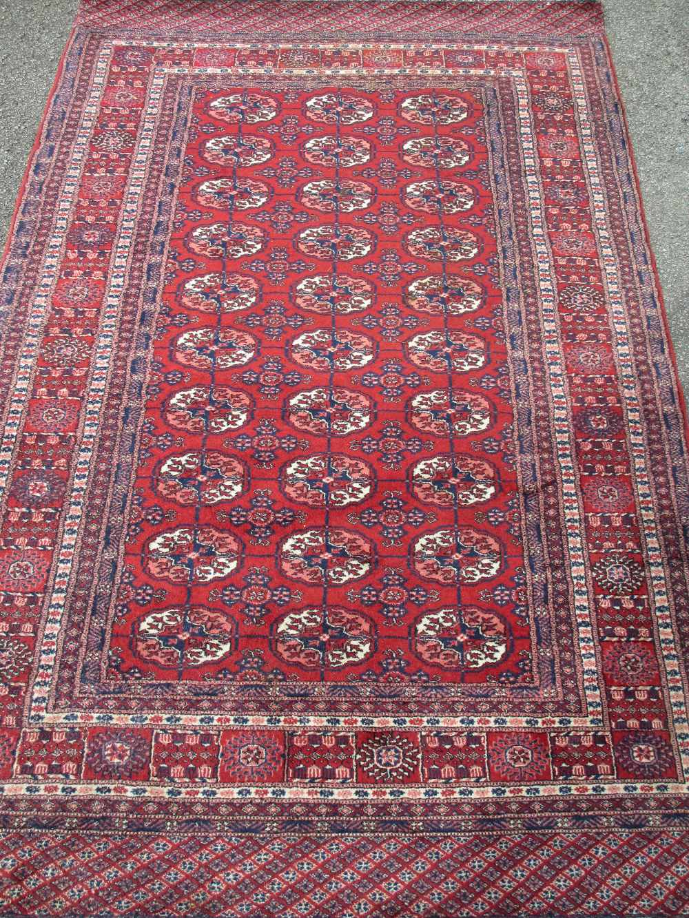 PERSIAN TYPE WOOLLEN RUG, red ground with a block pattern repeat centre and multi-bordered edge, 195