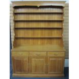 REPRODUCTION LIGHT OAK DRESSER having a four shelf rack with shaped sides on a base of three