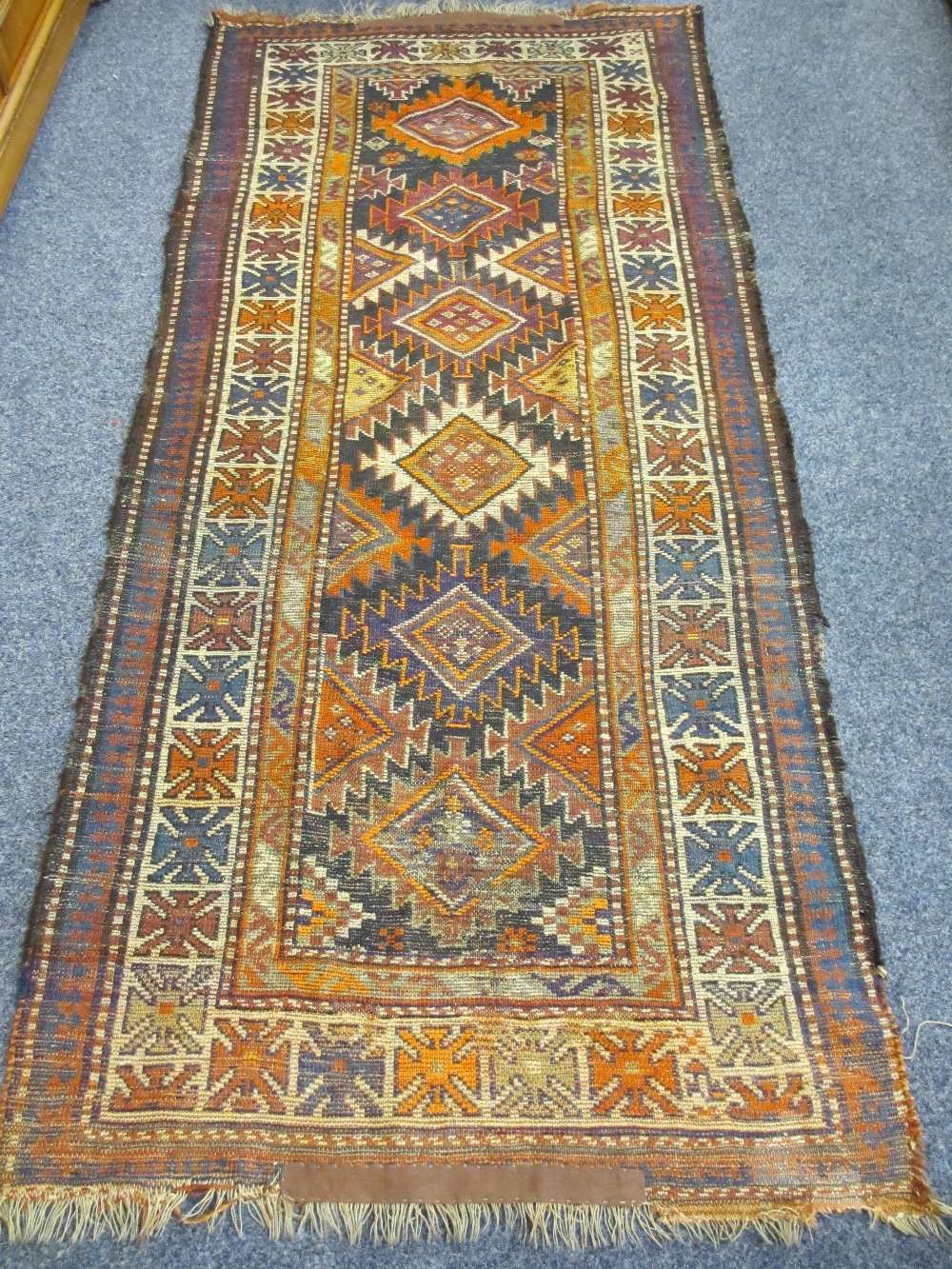 EASTERN WOOLLEN CARPET with central zig zag diamond pattern and multi-bordered edge (faded and