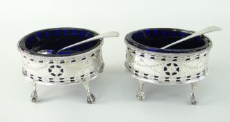 PAIR OF MATCHED 18TH CENTURY SILVER PIERCED AND ENGRAVED OVAL SALTS, each raised on four ball and