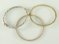 THREE 9CT GOLD LADIES BANGLES, of various design to include spiral and slotted screw head, 26gms