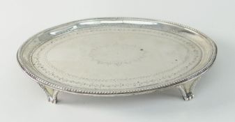 GEORGE III SILVER ENGRAVED OVAL TEAPOT STAND OR CARD TRAY, raised on four triform feet, London 1783,