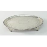 GEORGE III SILVER ENGRAVED OVAL TEAPOT STAND OR CARD TRAY, raised on four triform feet, London 1783,