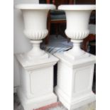 PAIR OF CONCRETE GARDEN URNS ON PEDESTAL BASES, later painted, urns 68cms high, overall 137cms