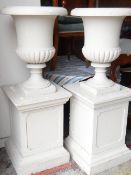 PAIR OF CONCRETE GARDEN URNS ON PEDESTAL BASES, later painted, urns 68cms high, overall 137cms