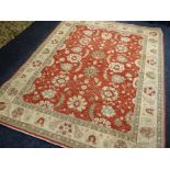 ORIENTAL RUG decorated with palmettes on a coral field, 240 x 300cms