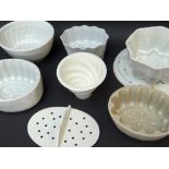 ASSORTED VINTAGE WHITE GLAZED POTTERY JELLY MOULDS & TWO DRAINERS