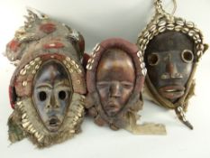 THREE DAN MASKS all with large shell decorated cloth assemblages (3)