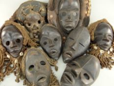 EIGHT VARIOUS DAN MASKS some with fibre and shell assemblages (8)