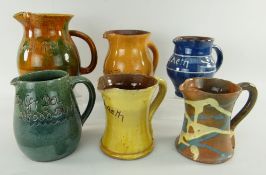 ASSORTED EWENNY POTTERY JUGS mostly inscribed including 'Llaeth, dwfr da rhod duw' ETC one dated