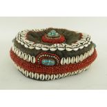 UNUSUAL TIBETAN OR NEPALESE CIRCULAR CLOTH HAT, applied with coral beads, cowrie shells, white metal