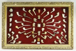 FRAMED DISPLAY OF 18TH & 19TH CENTURY CLAY PIPES some moulded decoration and text, approx. 63, in