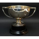 GEORGE V SILVER TWIN-HANDLED PRESENTATION TROPHY CUP, raised on ebonized circular socle base,