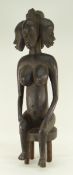 SENUFO SEATED FEMALE FIGURE, carved with five faces, 65cms high