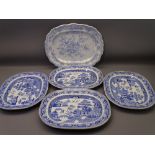 FIVE BLUE & WHITE POTTERY MEAT PLATTERS to include four Willow pattern, 40cms across and one Asiatic