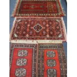 FOUR PERSIAN/MIDDLE EASTERN STYLE SCATTER RUGS, red grounds with pictorial, scattered and