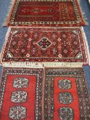 FOUR PERSIAN/MIDDLE EASTERN STYLE SCATTER RUGS, red grounds with pictorial, scattered and